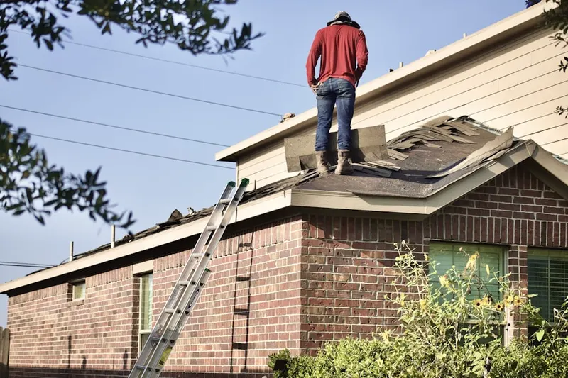 Professional roofer working on a residential roof in Sundance